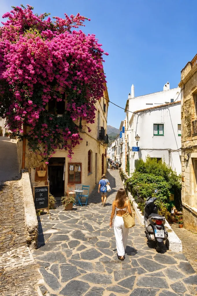 Bougainvillea-covered street in the historic old town of Cadaqués, Spain.