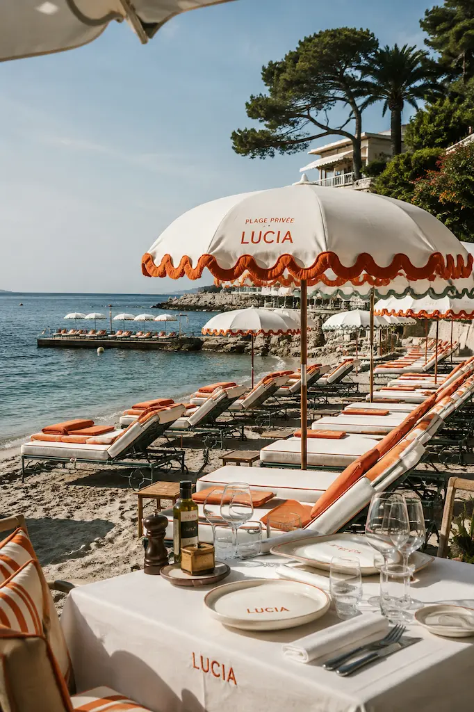Orange-and-white umbrellas and sun loungers at a chic French Riviera beach club beside the Mediterranean