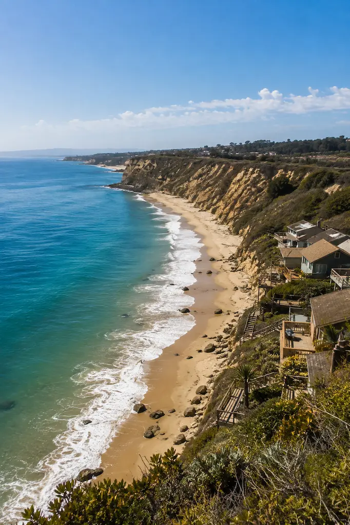 Blue Pacific water, sandy shoreline and golden coastal bluffs at Crystal Cove State Park in Orange County